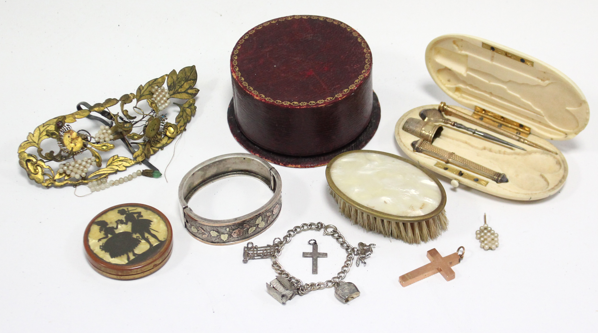 A 9ct. gold crucifix pendant; a silvered-metal hinged bracelet; a child’s charm bracelet, etc.