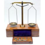 A brass scale mounted on mahogany box base, fitted long drawer; & a set of postal scales in fitted