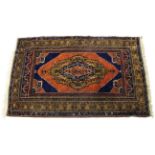 A Turkish rug of crimson & deep blue ground & with multi-coloured geometric design to centre