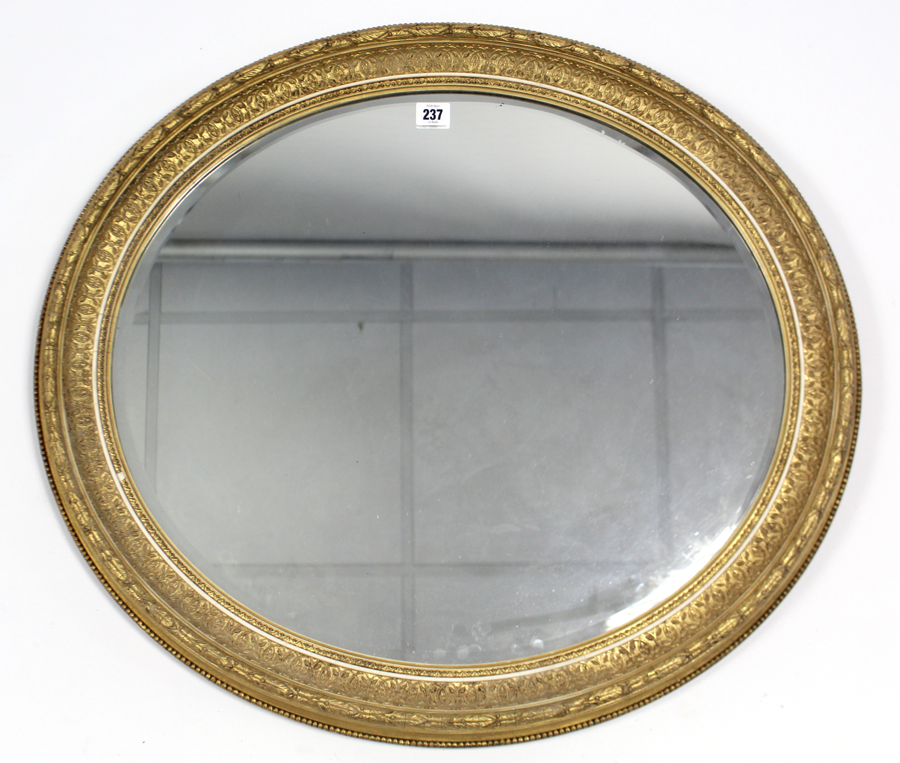 A 19th century gilt gesso frame oval wall mirror inset bevelled plate, 26” x 28”.