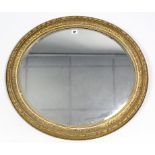 A 19th century gilt gesso frame oval wall mirror inset bevelled plate, 26” x 28”.