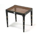 A regency-style ebonised painted cane-seat dressing table stool on ring- turned tapered legs, 18”