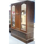 An Edwardian inlaid mahogany wardrobe, enclosed by rectangular bevelled mirror door to either side