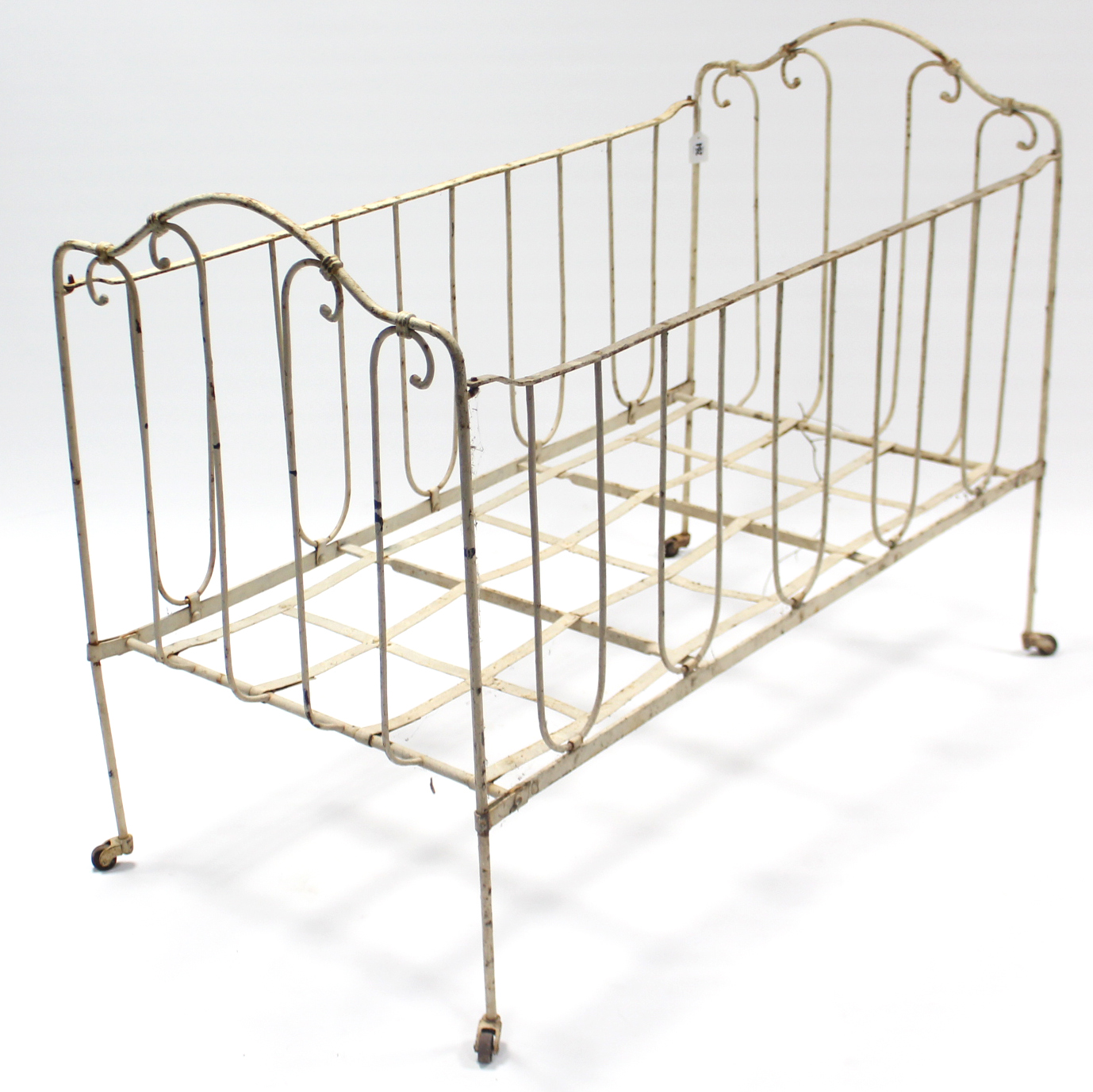 A late 19th/early 20th century white painted wrought-iron folding child’s bed, 45” long.