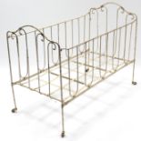 A late 19th/early 20th century white painted wrought-iron folding child’s bed, 45” long.