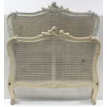 A continental-style white painted & carved wooden frame 3’ bedstead inset woven cane panel to the