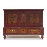 A 1930’s East European painted pine marriage chest with hinged lift-lid above a long drawer, & on
