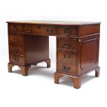 A reproduction mahogany pedestal desk inset gilt-tooled green leather cloth, fitted with an