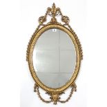 A reproduction gilt frame oval wall mirror in the Adam style, 36” x 19”.