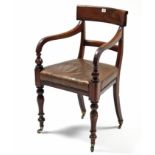 An early 19th century mahogany bow-back carver chair with padded seat, & on turned tapered legs with