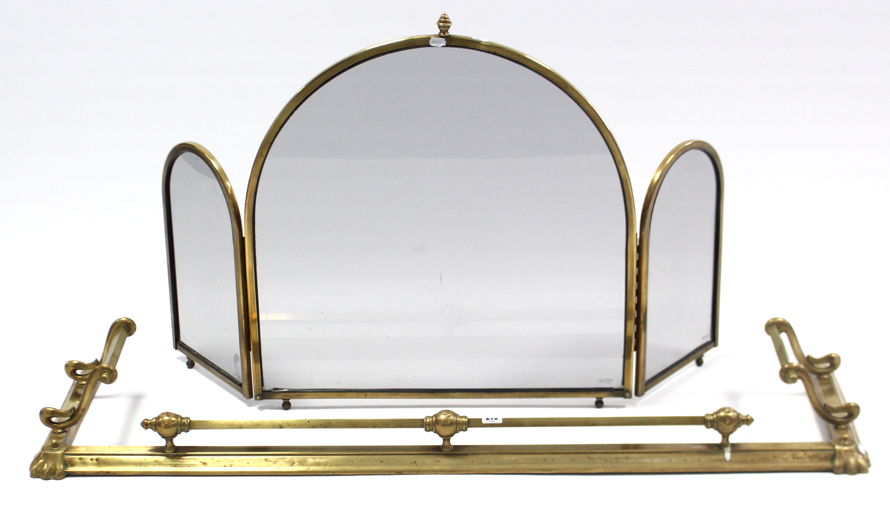 A brass fire curb, 51½” long; a set of three brass fire-implements; a brass-frame three-fold spark