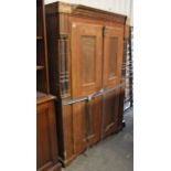 A continental-style grained pine wardrobe enclosed by pair of panel doors, with half turned