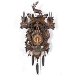 A mid/late 20th century cuckoo wall clock in carved wooden case, 24” high.