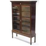 A mahogany display cabinet, with four adjustable shelves enclosed by pair of glazed doors, & on