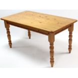 A pine kitchen table with rounded corners to the rectangular top, & on four turned legs, 60” x
