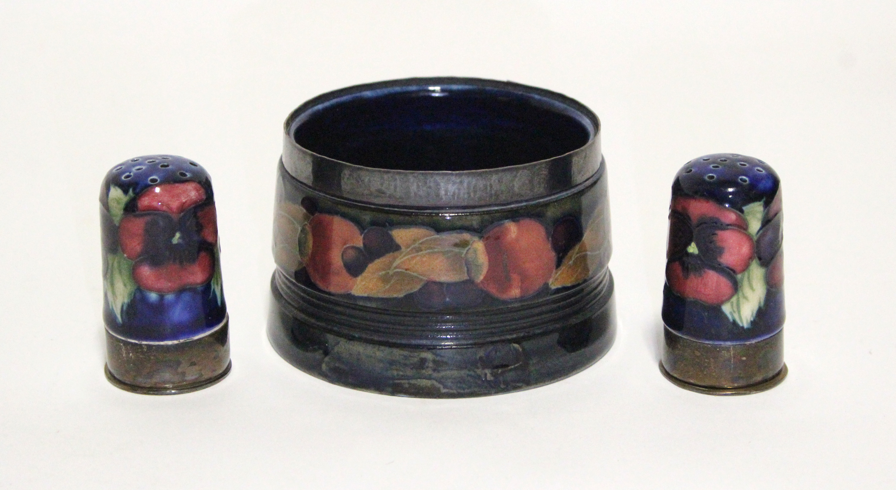 A Moorcroft “Pomegranate” round tapered pot with pewter rim, painted initials & impressed marks,