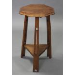 An Arts & Crafts style oak occasional table with octagonal top, on three tapered & pierced legs with