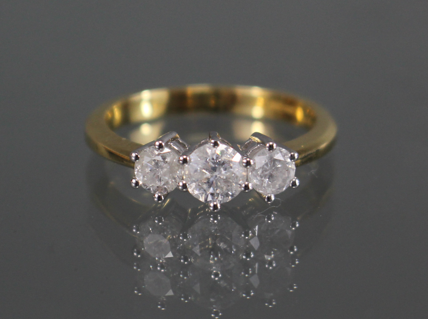 An 18ct. gold ring set three graduated diamonds, the centre stone approx. 0.5 carat, the two smaller