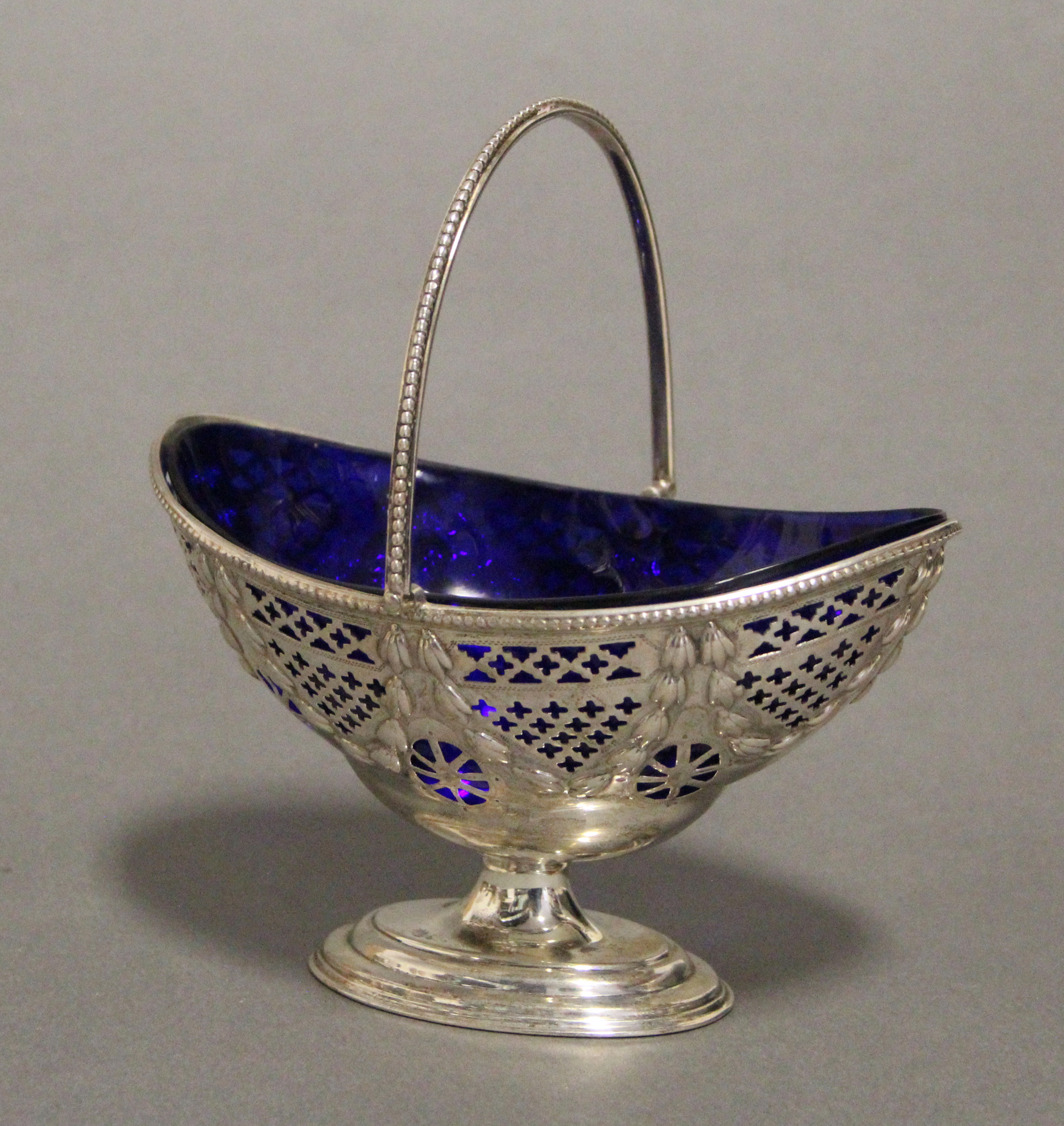 A modern silver pierced oval sugar basin in the late 18th century style, with beaded rim, swing