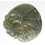 A Chinese carved & pierced jade roundel in the form of a fish amongst fronds; 2” wide.