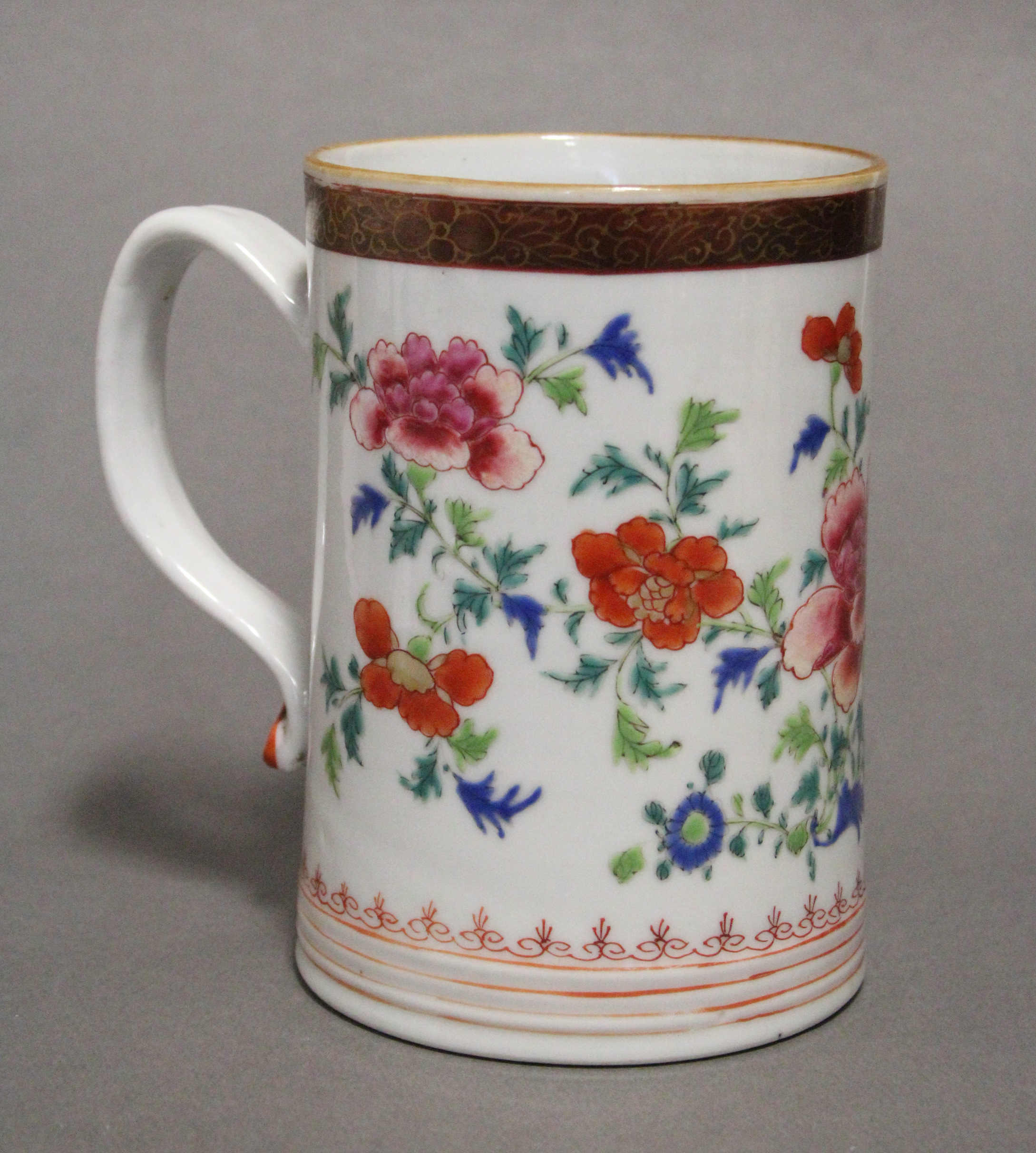 An 18th century Chinese porcelain large cylindrical tankard painted in bright famille rose enamels