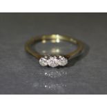 An 18ct. gold ring set three small diamonds; size: Q; weight: 2.4gm.