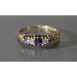 A late 19th/early 20th century 18ct. gold ring set three sapphires with diamonds in between; size: