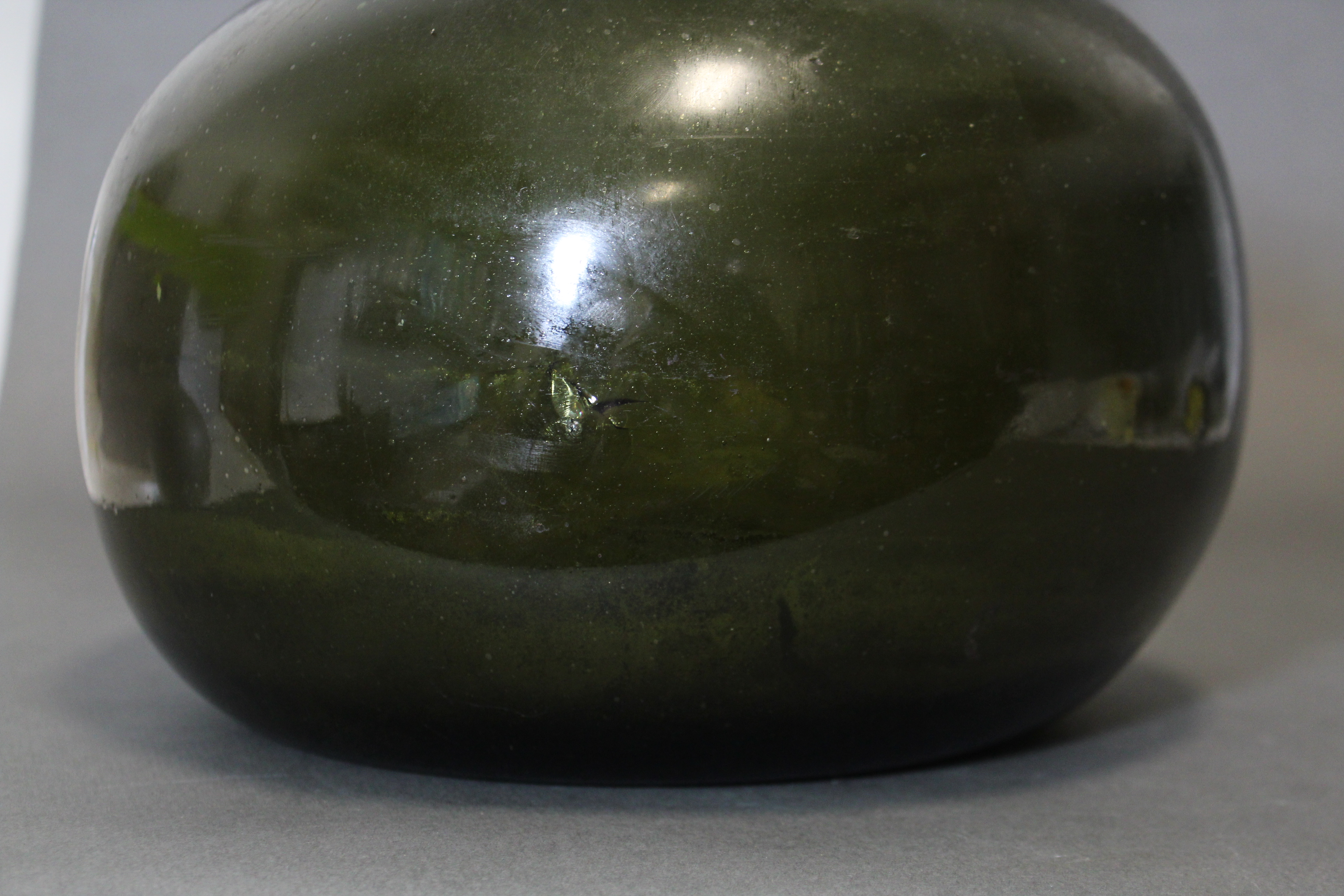 An 18th century green glass wine bottle of squat “onion” form, with tapered neck, 10¾” high. (slight - Image 4 of 6