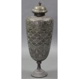 A large Islamic brass floor-standing vase, with tapered cylindrical body & domed cover, all-over