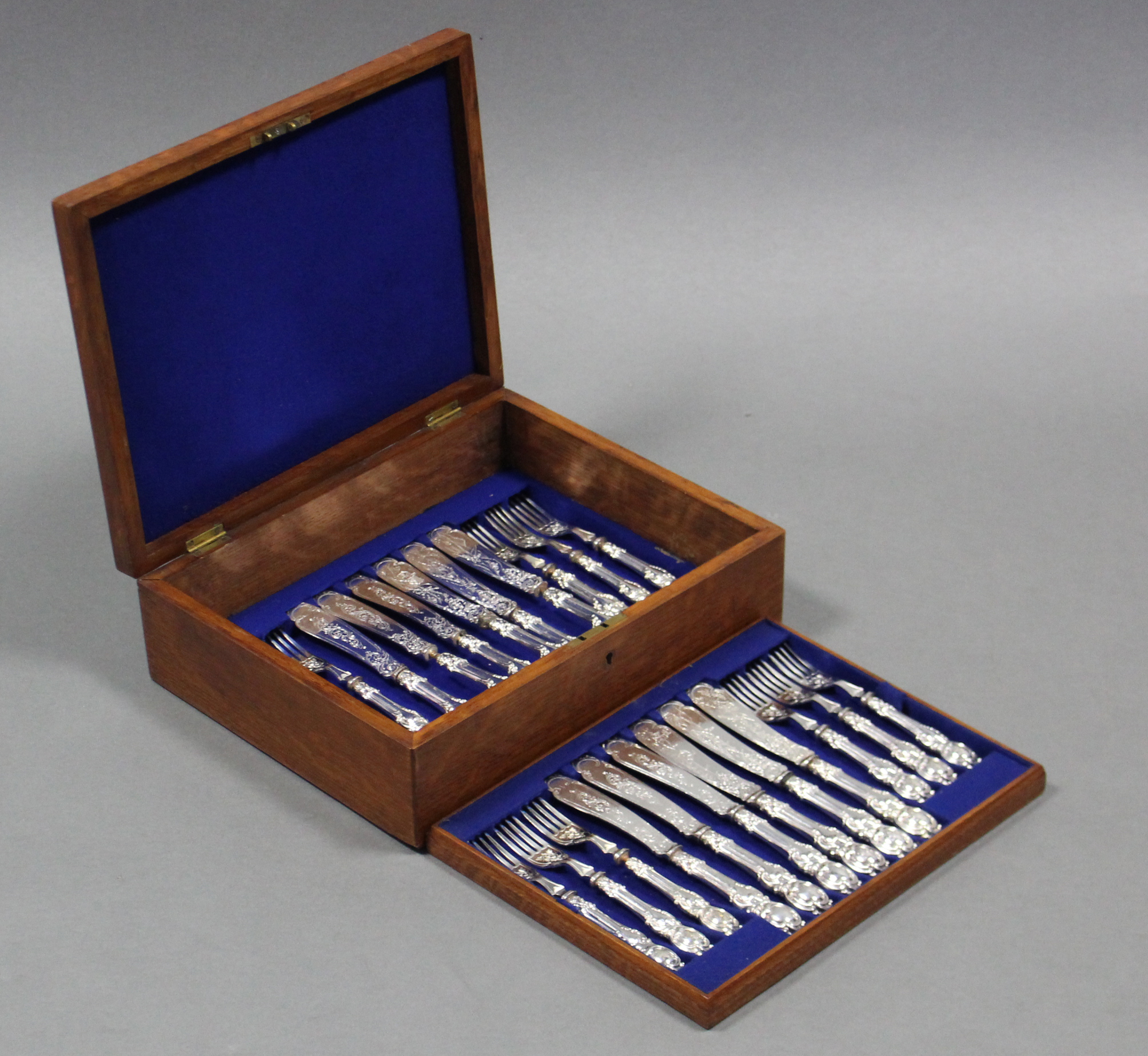 Twelve pairs of late Victorian engraved fish knives & forks, in fitted oak case.