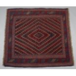 A Kazak rug of crimson, deep blue, & ivory ground with central hook & lozenge motif within