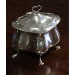 An Edwardian silver tea caddy of quatrelobe shape, with swing handle to the hinged lid, & on four