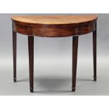 A Georgian mahogany tea table with demi-lune fold-over top, on square tapered legs, 37¼” wide.