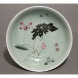 An 18th century Chinese porcelain saucer dish of celadon ground, painted with lotus flowers, leaves,