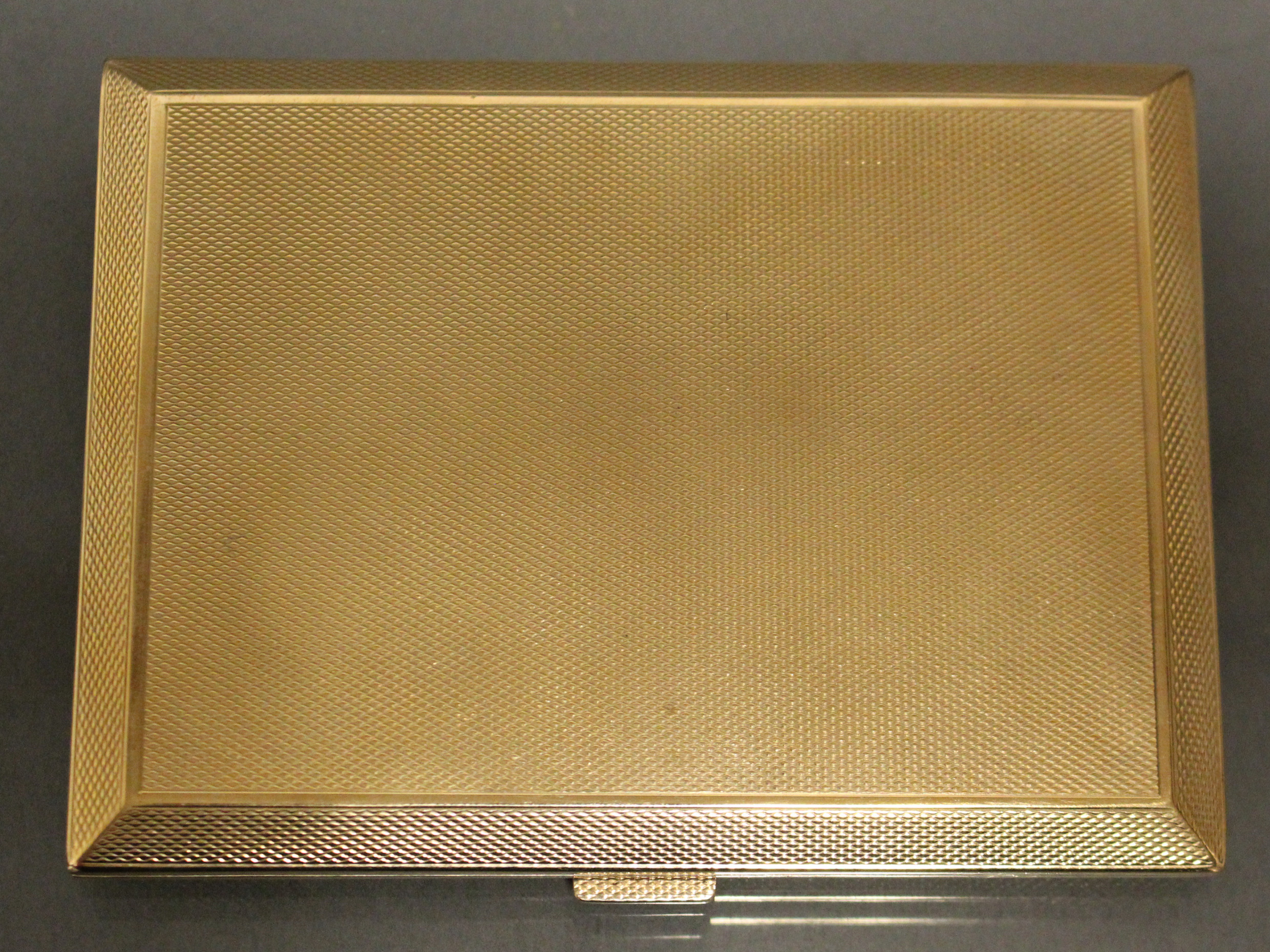 A 9ct. gold engine-turned rectangular pocket cigarette case, 4¼” x 3¼”; Birmingham hallmarks for