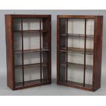 A pair of early 19th century mahogany wall cabinets with glazed doors, each fitted with three