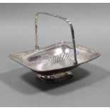 A large rectangular semi-fluted cake basket with gadrooned rim, swing handle, & on low pedestal
