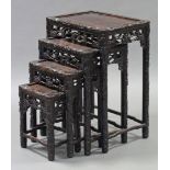 A late 19th/early 20th century Chinese nest of four carved hardwood occasional tables with all-