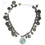 A Byzantine bronze necklace of decorated flat circular panels with small plain beads in between.