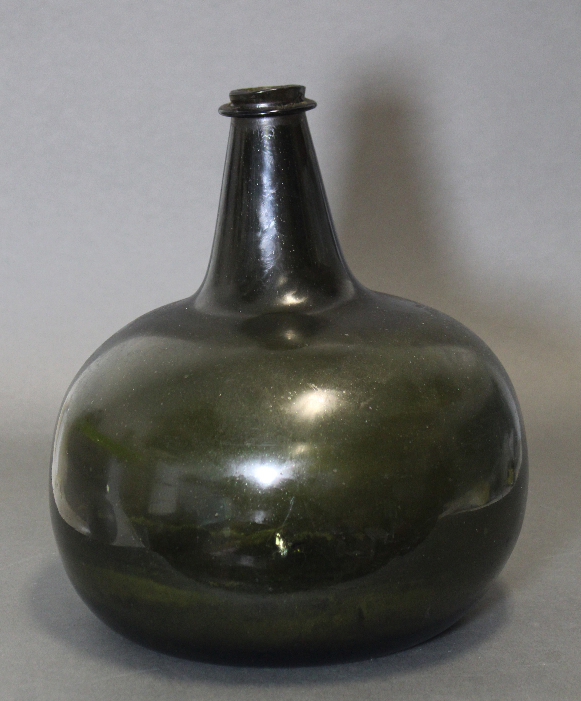 An 18th century green glass wine bottle of squat “onion” form, with tapered neck, 10¾” high. (slight - Image 3 of 6