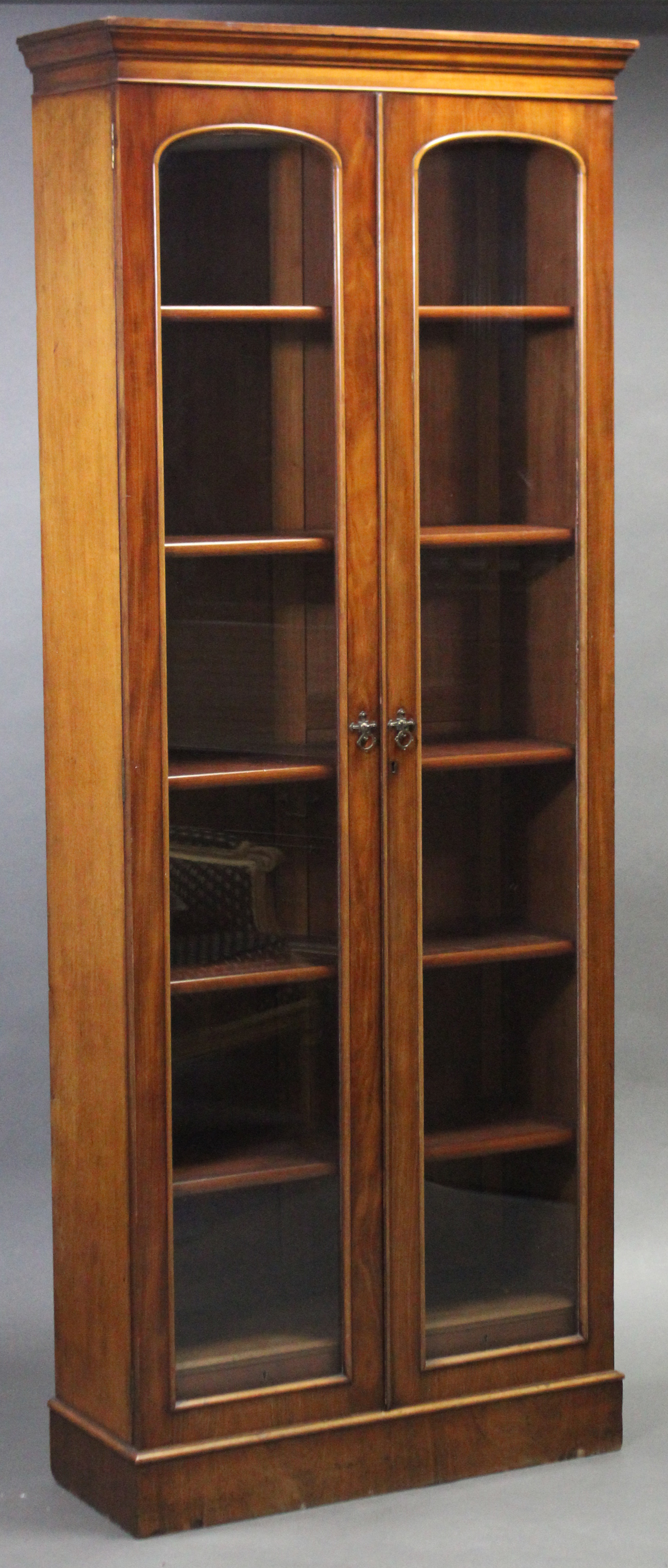 A late Victorian tall standing mahogany bookcase, fitted five adjustable shelves above two short