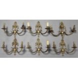 A set of six 20th century cast brass twin-branch wall lights of classical design, each 13” wide x