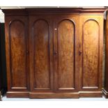 A Victorian figured mahogany break-front wardrobe, fitted four sliding trays to the centre above