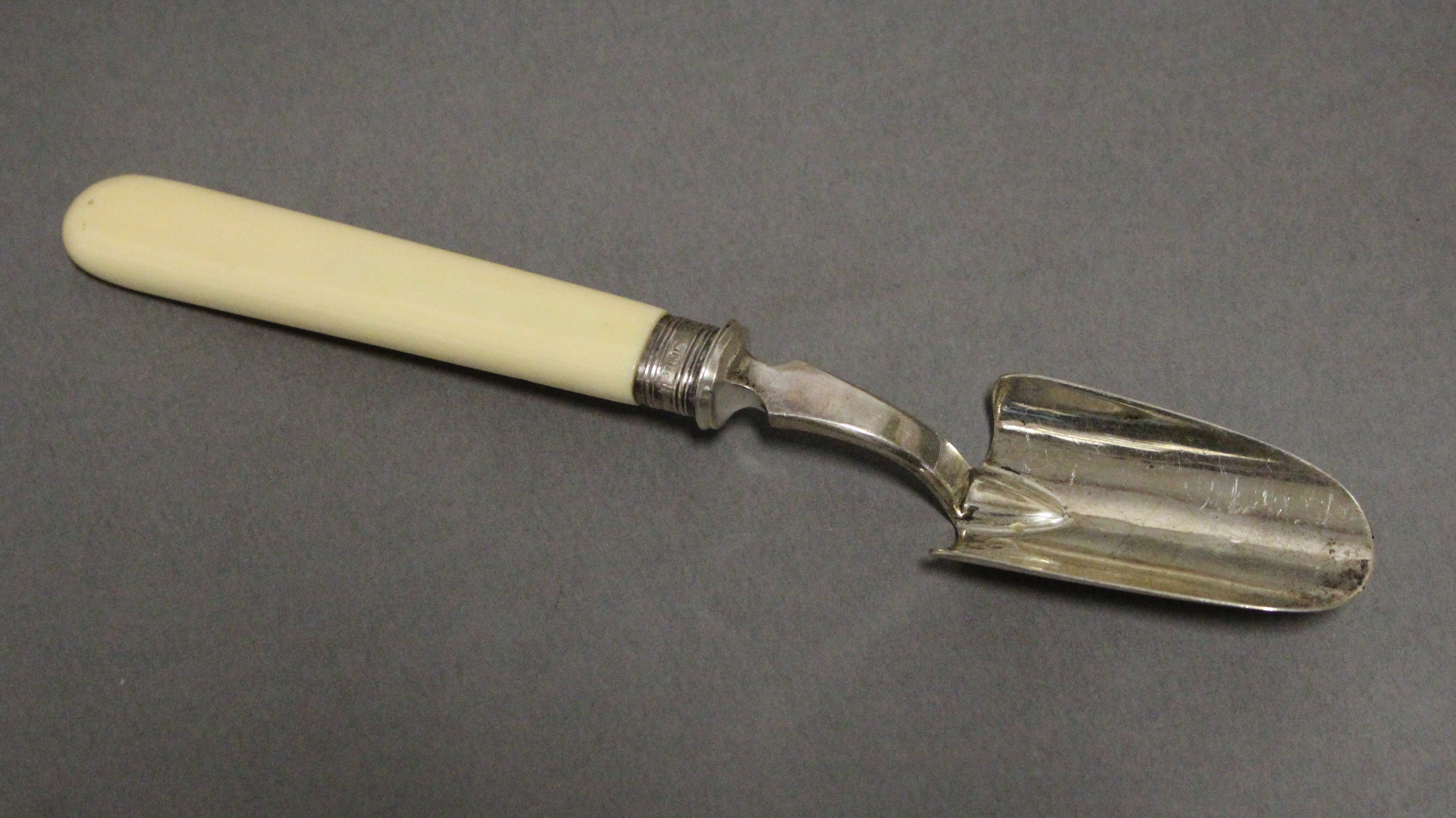 A late Victorian silver cheese scoop with plain ivory handles, 8” long; London 1898 by W. S.