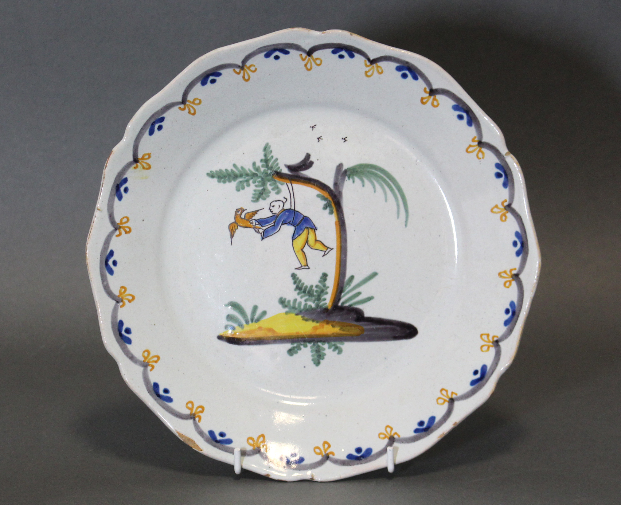 An 18th century French faience pottery circular dish, with shaped rim & painted polychrome - Image 2 of 3