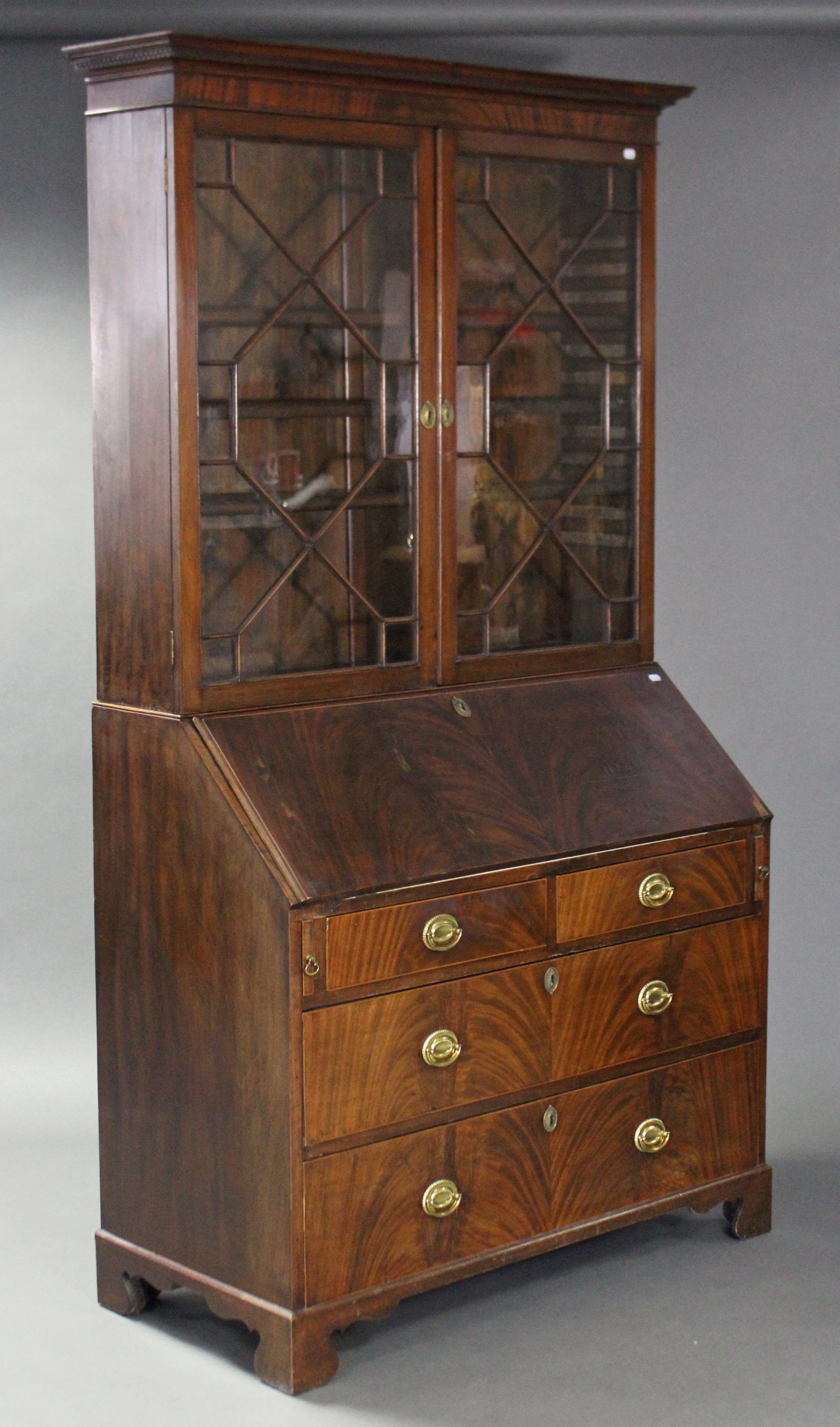 A George III figured mahogany bureau bookcase, with moulded Greek Key pattern cornice, fitted