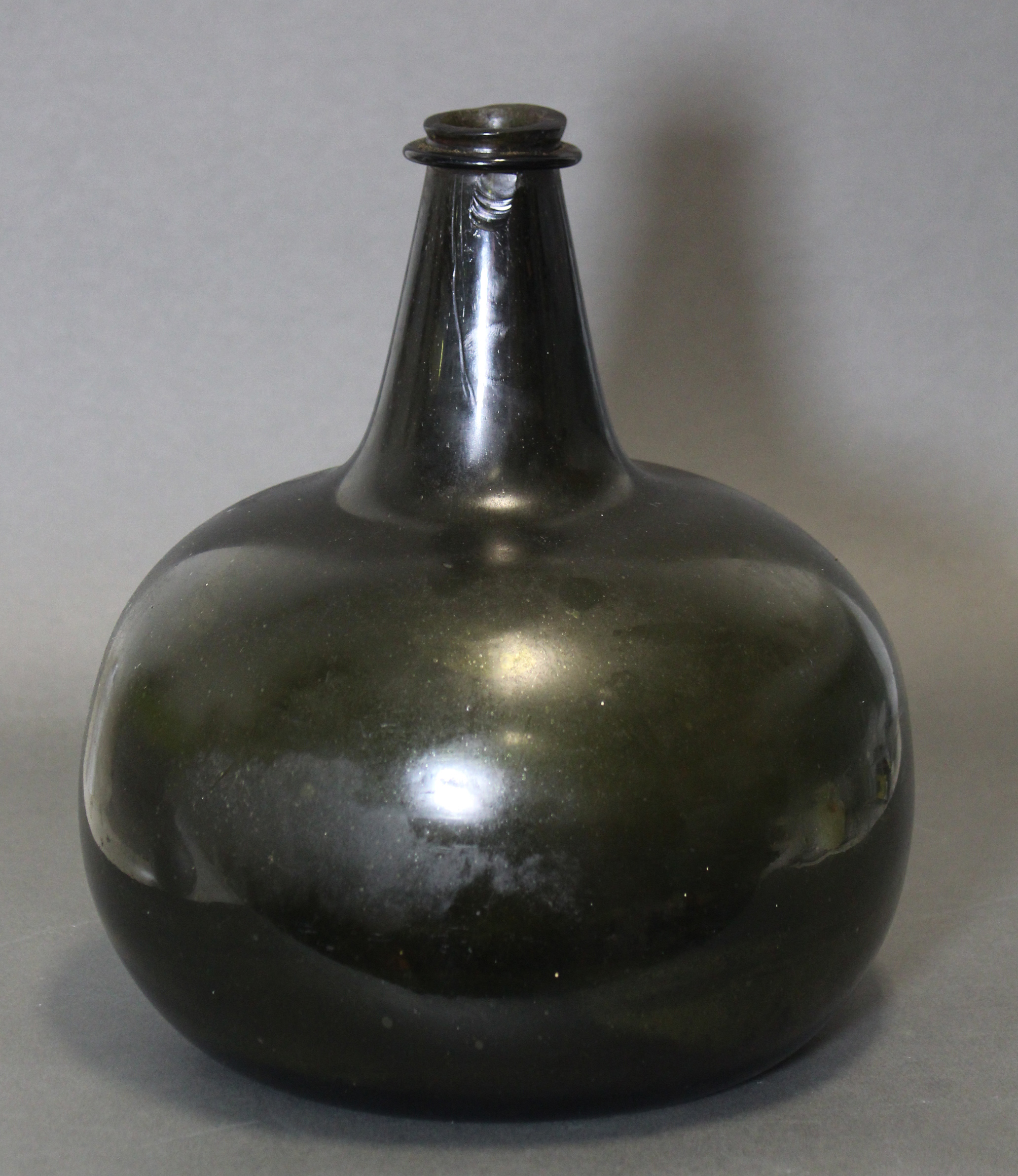 An 18th century green glass wine bottle of squat “onion” form, with tapered neck, 10¾” high. (slight - Image 2 of 6