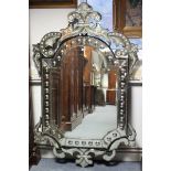 A large Venetian glass wall mirror, the central shaped rectangular bevelled plate in beaded &