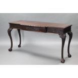 A GEORGE II style CARVED MAHOGANY SERVING TABLE, the rectangular break-front top with foliate
