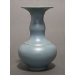 A Chinese pale blue glazed porcelain squat round vase with wide flat rim to the narrow neck, bears